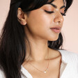 Model looking down wearing Pearl and Crystal Moon and Stars Necklace in Gold