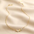 Pearl and Crystal Moon and Stars Necklace in Gold Full length on neutral coloured fabric