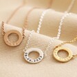 Personalised Eternity Ring Pendant Necklaces in rose silver and gold laid on neutral coloured fabric