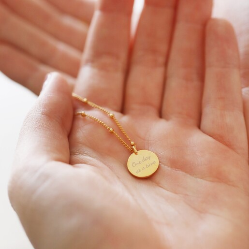 Model holding Personalised Talisman Satellite Chain Pendant Necklace in Gold in palm of hand showing back of pendant