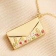 Close up of Personalised Wildflower Envelope Locket Pendant Necklace in Gold closed on top of beige coloured fabric