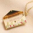 Personalised Wildflower Envelope Locket Pendant Necklace in Gold open with token inside on top of beige coloured backdrop