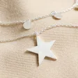 Close up of pendant on Silver Double Layer Star Necklace against neutral material