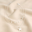 Silver Double Layer Star Necklace on top of beige coloured fabric