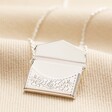 Envelope Locket Necklace in Silver with locket open on beige coloured fabric
