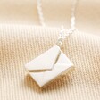 Small Silver Envelope Necklace on Beige Fabric