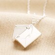 Open Small Silver Envelope Necklace on Beige Fabric