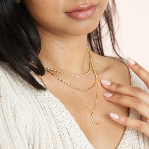 Model Touching Shoulder Wearing Crescent Moon Pendant Necklace in Gold