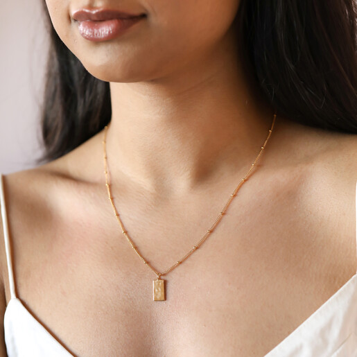 Model wearing Tiny Hammered Tag Pendant Necklace in Gold