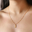 Model wearing Tiny Hammered Tag Pendant Necklace in Gold