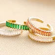 Adjustable Green Baguette Crystal Band Ring in Gold with other colours stacked on top of neutral coloured backdrop