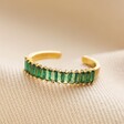 Adjustable Green Baguette Crystal Band Ring in Gold on top of beige coloured fabric