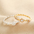 Dainty Pearl and Crystal Stacking Rings in Gold and Silver on Beige Fabric