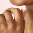 Close up of Dainty Rose Quartz and Crystal Ring in Gold on model