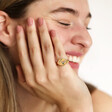 Model smiling wearing Personalised Multicoloured Crystal Daisy Signet Ring in Gold in front of a white background