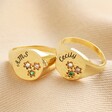 Personalised Multicoloured Crystal Daisy Signet Ring in Gold stacked on top of each other on neutral fabric