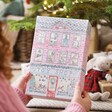 Model holding Personalised Fill Your Own Toy Shop Advent Calendar in front of christmas tree