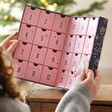 Model holding Personalised Fill Your Own Celestial Advent Calendar open in front of Christmas tree