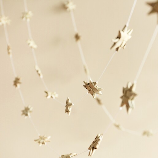 Afroart Natural Stars on a String Garland hanging in front of neutral coloured backdrop