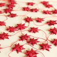 Afroart Red Stars on a String Garland laid out on neutral background