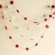 Afroart Red Stars on a String Garland with natural garland in front of neutral background