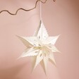 Afroart Sirius Star Hanging Decoration hanging from tree branch against natural coloured backgound