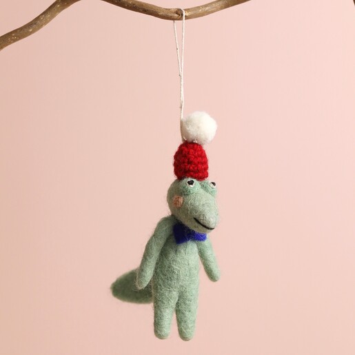 Felt Christmas Crocodile Hanging Decoration on Branch Against Pink Background 