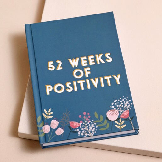 Teal Floral 52 Weeks of Positivity Diary on top of raised surface with beige backdrop