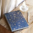Blue Starry Night Lined Notebook on top of wooden surface with pencil to the side