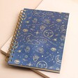 Blue Starry Night Lined Notebook on top of pink surface