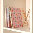 Pink Cat Lined Notebook in lifestyle shot on top of shelf with reed diffuser