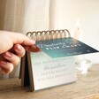 Model opening Celestial Positivity Flip Chart on top of wooden surface