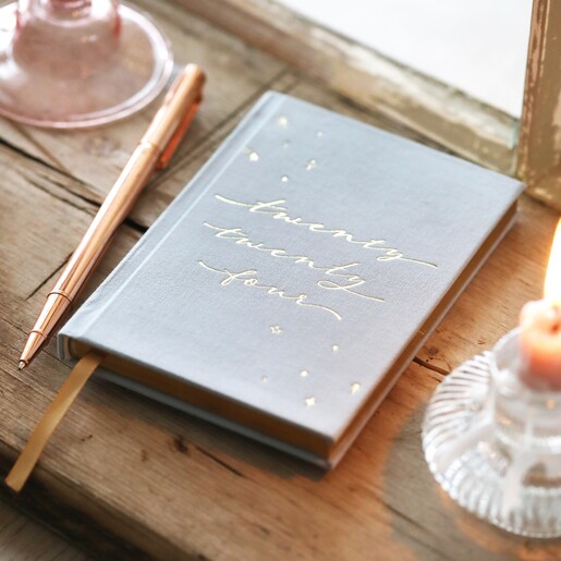 Dusky Blue 2024 Diary on top of wooden counter with pen to the side