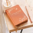 Personalised Orange Five Year Thought a Day Journal in lifestyle shot on top of wooden counter with pen to side