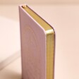 Close up of page edges on Pink Sun and Moon Fabric Notebook with beige background
