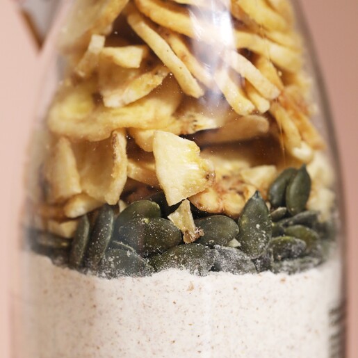 Close up of biscuit mix inside of Doggy Baking Co. Banana and Pumpkin Seed Biscuit Mix bottle