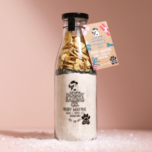 Doggy Baking Co. Banana and Pumpkin Seed Biscuit Mix in front of neutral background surrounded by fake snow