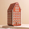 Kopernik Polish Chocolate Covered Gingerbread Tin closed showing house-shaped tin in front of beige surface