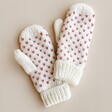 Mittens From White and Pink Knitted Bobble Hat and Mittens Set on Beige Background