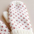 Close Up of Mittens from White and Pink Knitted Bobble Hat and Mittens Set against neutral background
