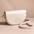 Woven Vegan Leather Crossbody Bag in Beige in front of neutral coloured backdrop