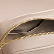 Close up of inside of Rectangular Crossbody Bag in Beige against beige coloured backdrop