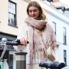 Model wearing Rectangular Crossbody Bag in Beige with scarf holding bike handle