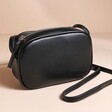 Rectangular Crossbody Bag in Black on top of beige coloured surface