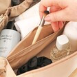 Model pulling makeup brush from the centre pocket of Rectangular Makeup Bag in Pink