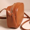 Side of Rectangular Crossbody Bag in Tan showing zip on beige coloured backdrop