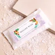 Lisa Angel Mulled Wine Soy Wax Melts inside of packaging on beige backdrop with fake snow