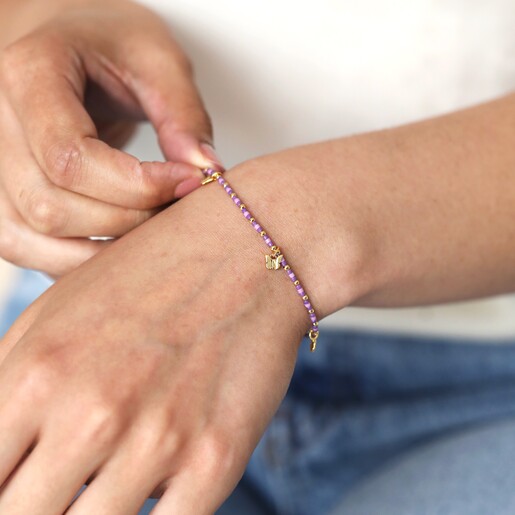 Estella Bartlett Butterfly Charm Bracelet in Gold on model's wrist with beads being touched