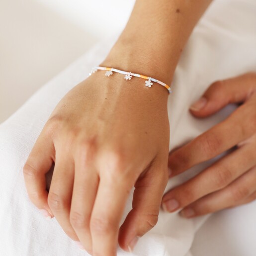 Close Up of Estella Bartlett Ditsy Flower Miyuki Charm Bracelet In Silver on Model's Wrist