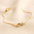 Estella Bartlett Multicoloured Crystal Infinity Bracelet In Gold on Beige Fabric